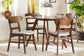 Mid-century modern wood dining set with round table and four chairs in bright dining room