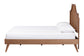 Mid-century modern wooden bed frame with cane headboard and white bedding