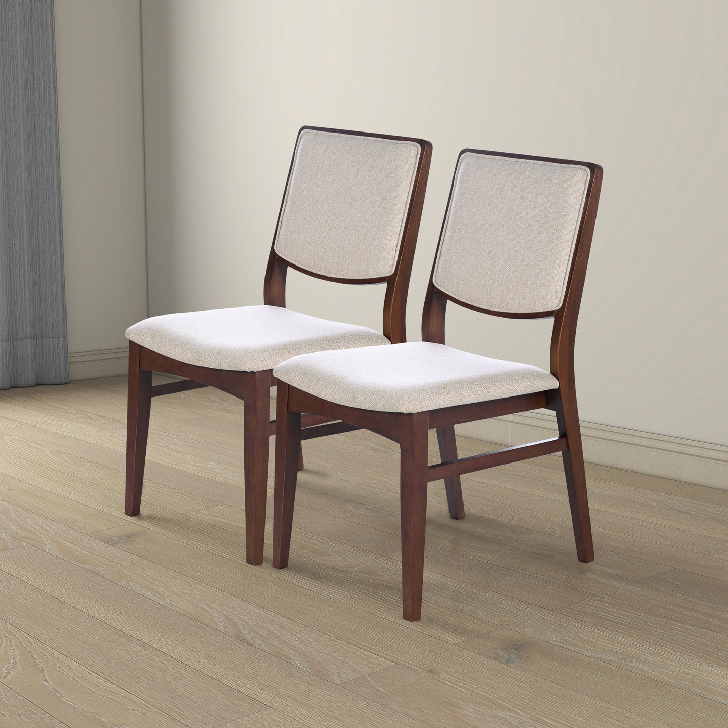 Pair of modern wooden dining chairs with light beige cushions on a hardwood floor