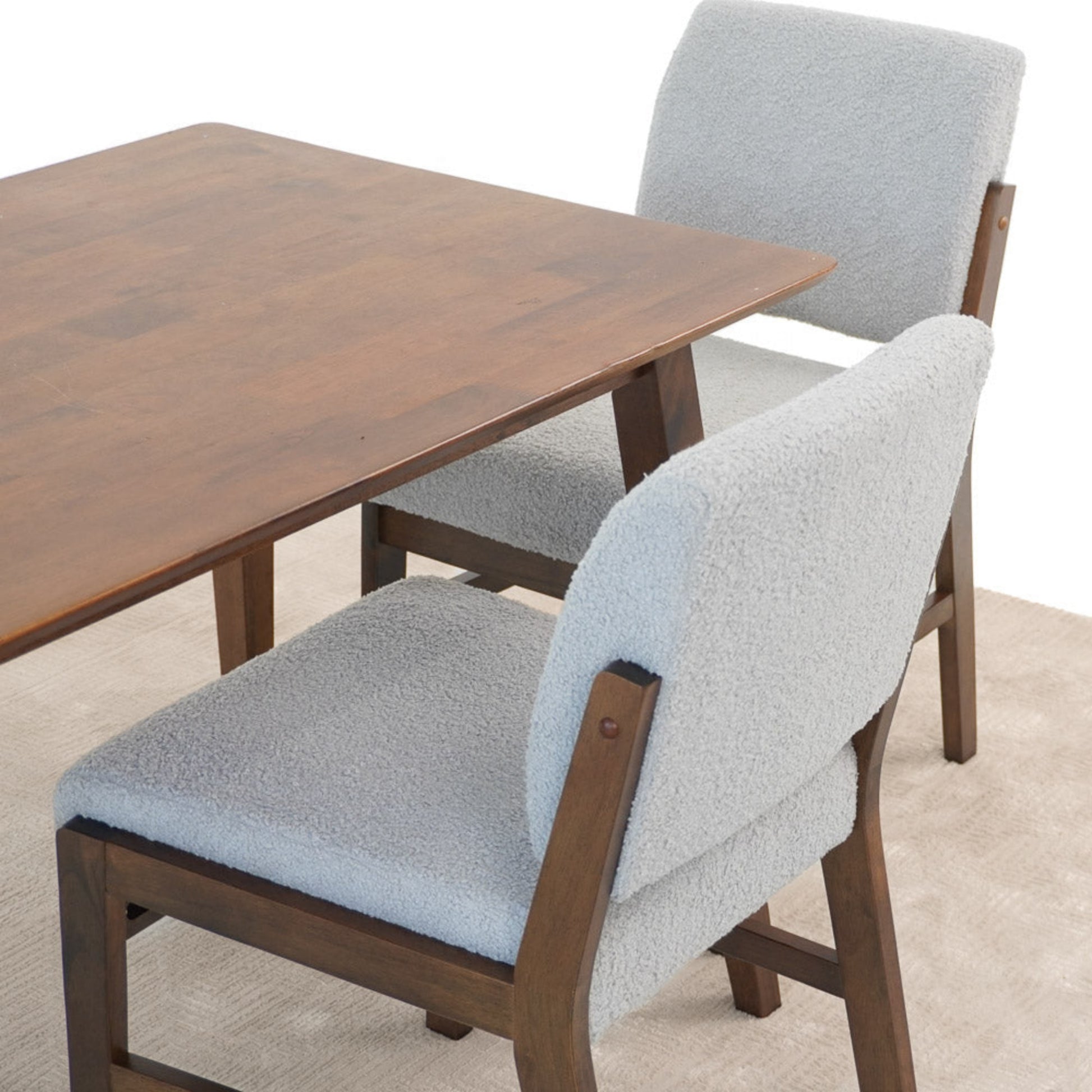 Modern dining set with wooden table and two light gray cushioned chairs on beige rug