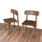 Pair of modern wooden dining chairs with curved backs on wood floor, FredCo International