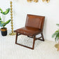 Mid-century modern brown leather accent chair in a bright living room with gold decor and plants