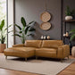 Modern tan sectional sofa in stylish living room with plants and woven wall decor, FredCo International furniture