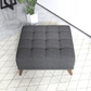 Modern tufted dark gray ottoman on patterned rug in contemporary living room