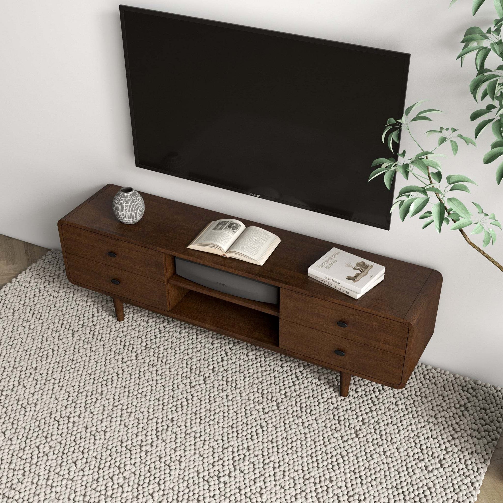 Modern wooden TV stand with drawers, decor, and books in a living room, FredCo International furniture.