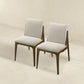 Pair of modern beige upholstered dining chairs with wooden legs on a neutral background