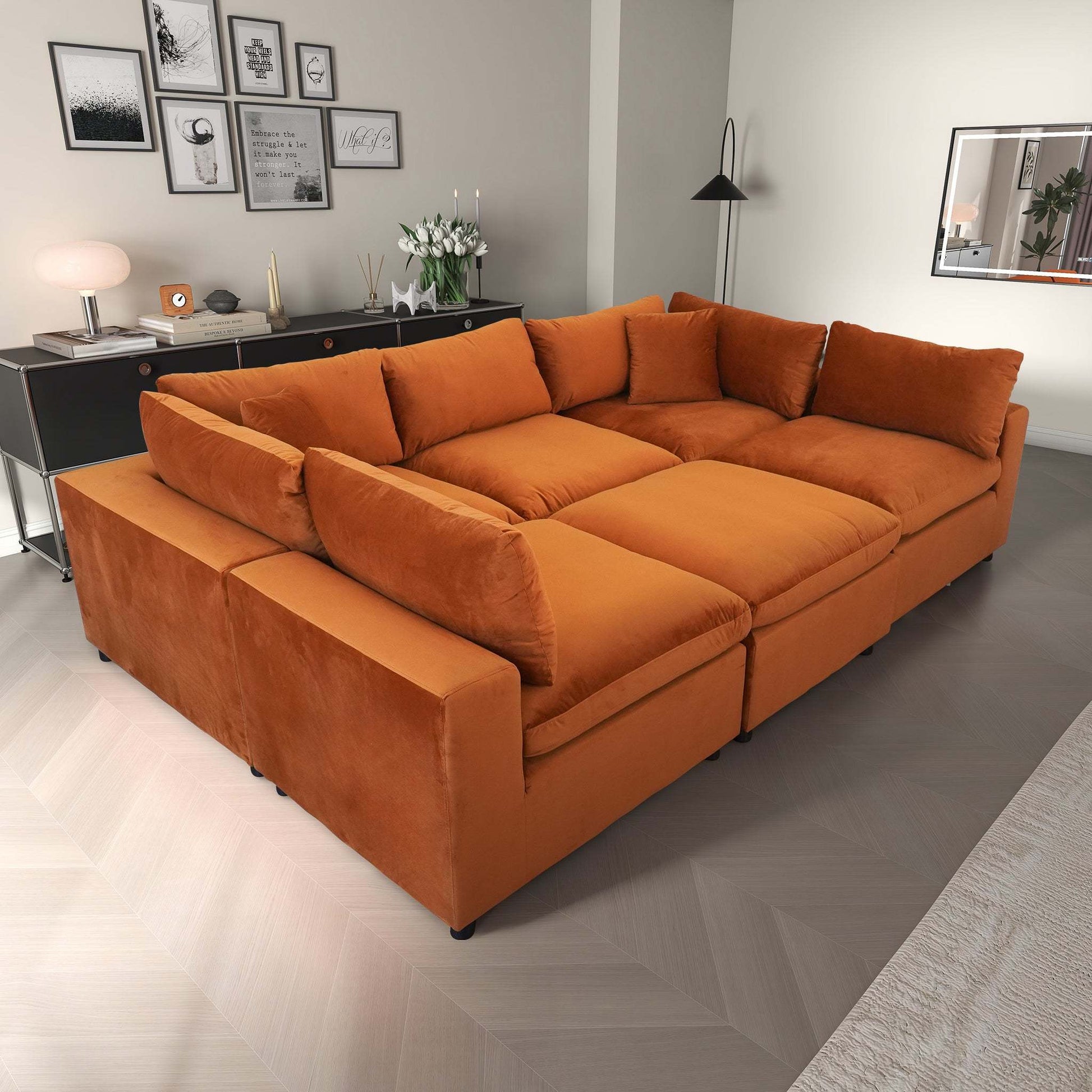 Modern living room with large orange sectional sofa, wall art, and contemporary decor from FredCo International