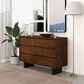 Modern wood dresser with six drawers in a stylish home setting, next to a floor lamp and plant