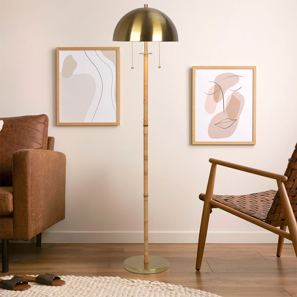 Modern living room with brass floor lamp, leather sofa, woven chair and minimalist wall art