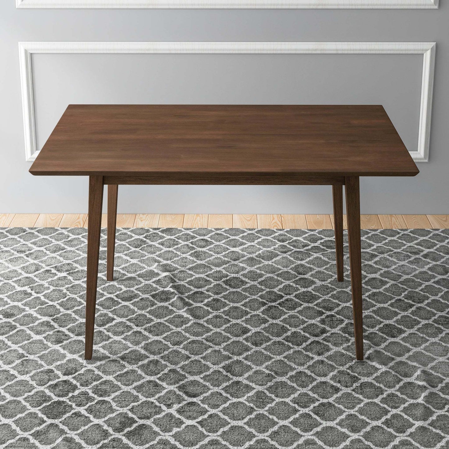 Modern wooden dining table on patterned gray rug in minimalist home setting