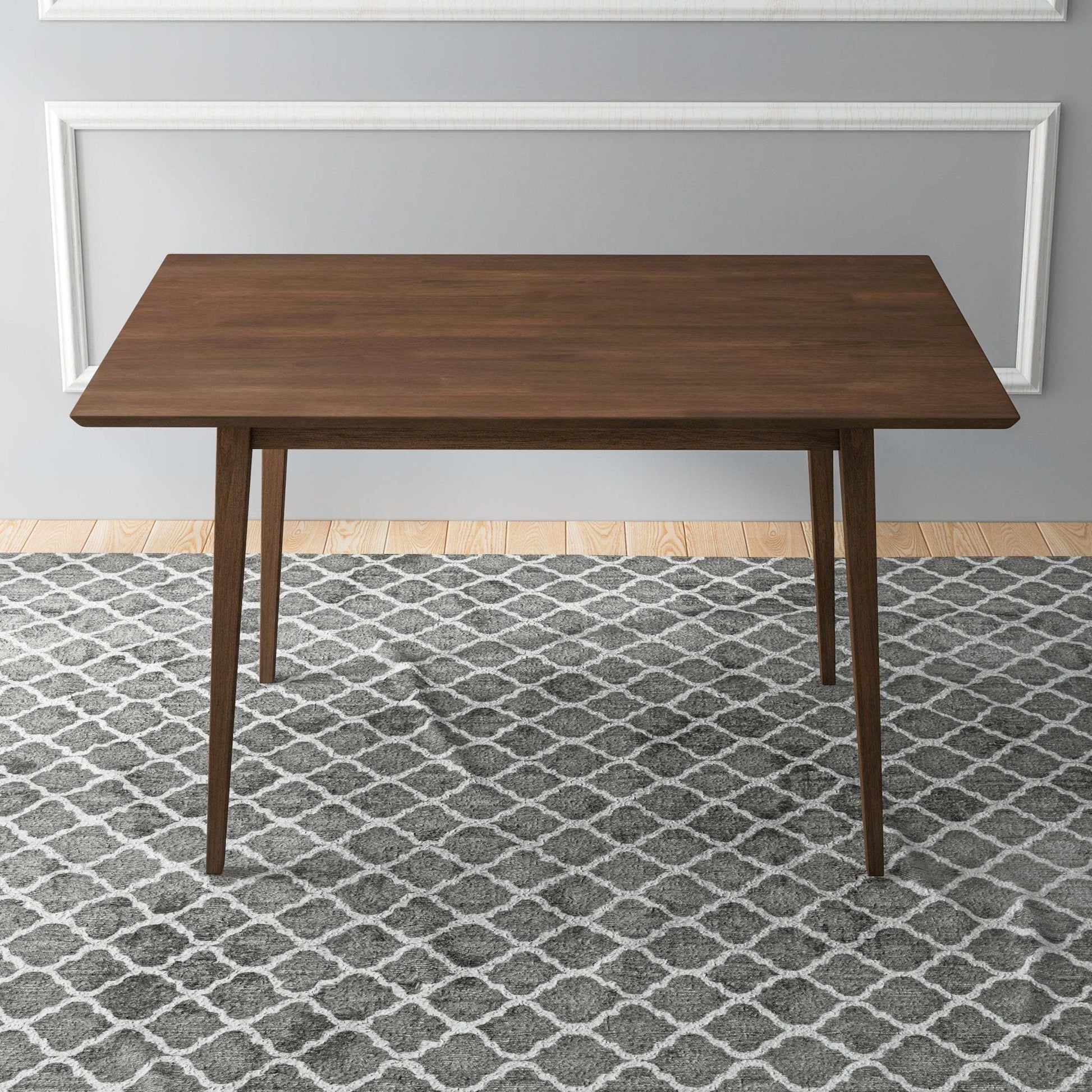 Modern wooden dining table on patterned gray rug in minimalist home setting