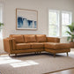 Modern tan leather sectional sofa in bright living room with large windows and wall art