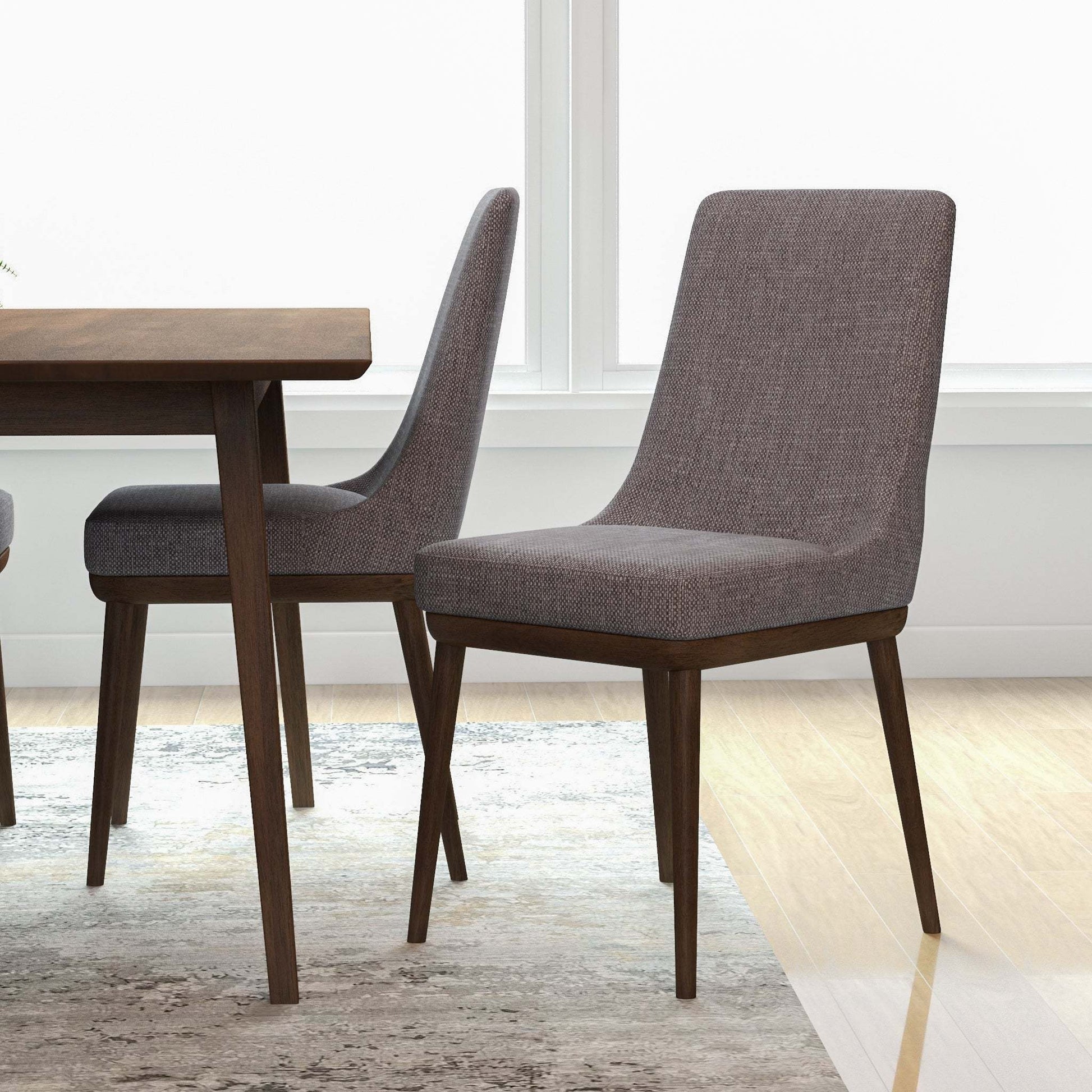 Modern gray dining chairs with wood legs next to dining table in bright home interior
