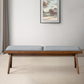 Modern wood bench with gray upholstered cushion in minimalist living room, FredCo International furniture