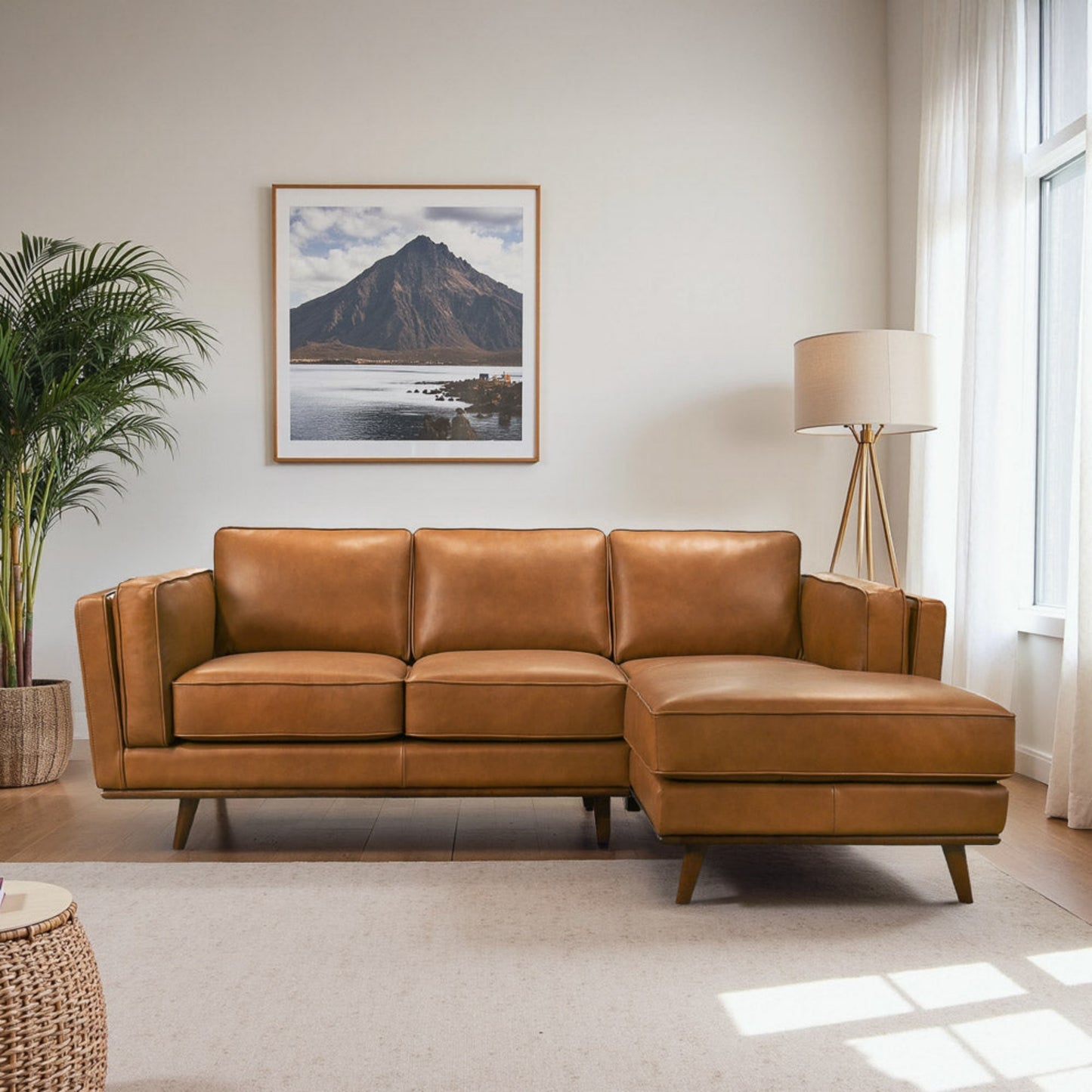 Modern tan leather sectional sofa in bright living room with floor lamp and mountain wall art