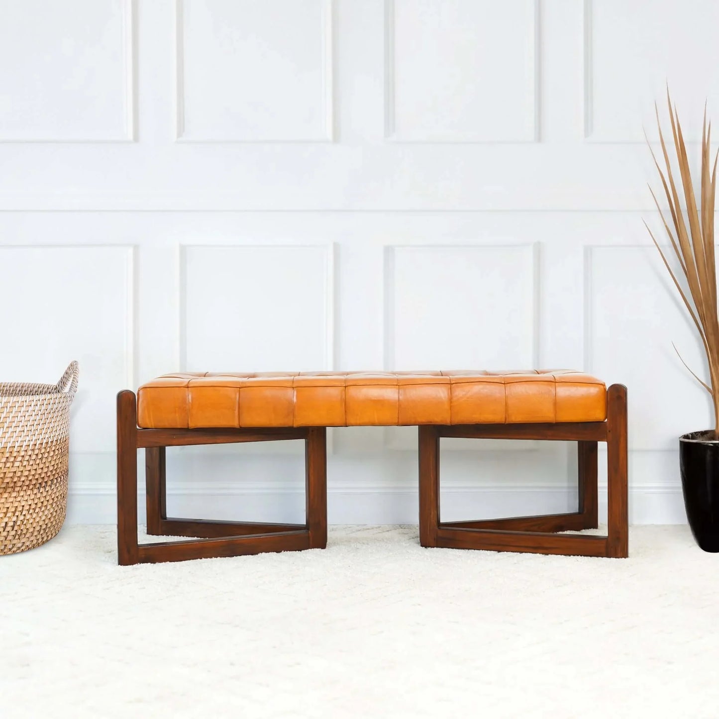 Mid-century modern tan leather bench with wooden legs in a bright living room, FredCo International furniture