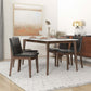 Modern dining room with wood table, black chairs, set for four, and abstract wall art