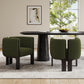 Modern dining room with green upholstered chairs, black table, art on wall, and window view