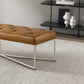 Modern brown leather bench with metal legs on textured rug in stylish home interior