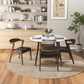 Modern dining room with round table and four chairs on woven rug, minimalist decor, FredCo International furniture