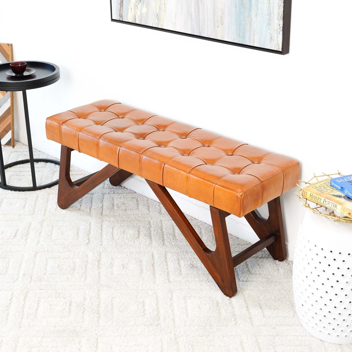 Modern tan tufted leather bench with wooden legs in a stylish home interior