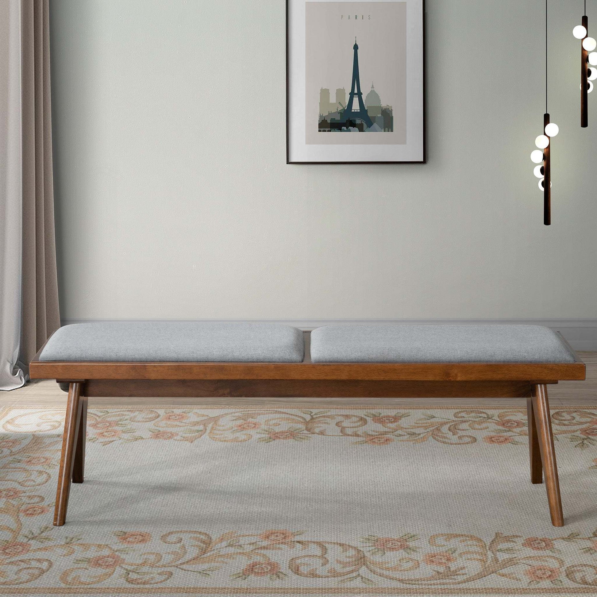 Mid-century modern wood bench with gray cushion on floral rug, stylish living room decor
