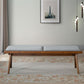 Mid-century modern wood bench with gray cushion on floral rug, stylish living room decor