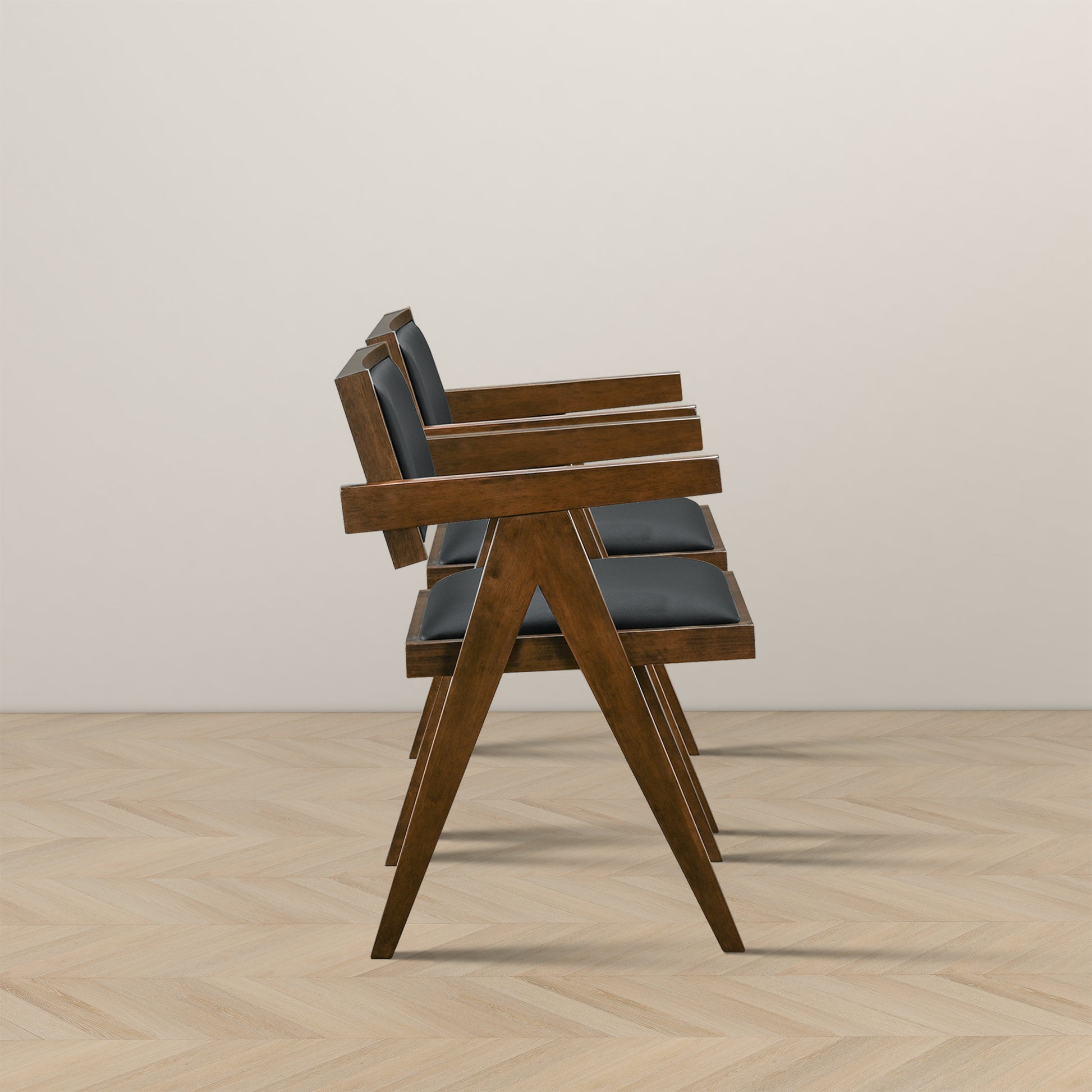 Modern wooden armchairs with black cushions, side view, on light chevron wood floor