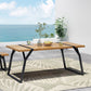 Modern wood dining table with black metal legs on patio, ocean view, and decorative plants