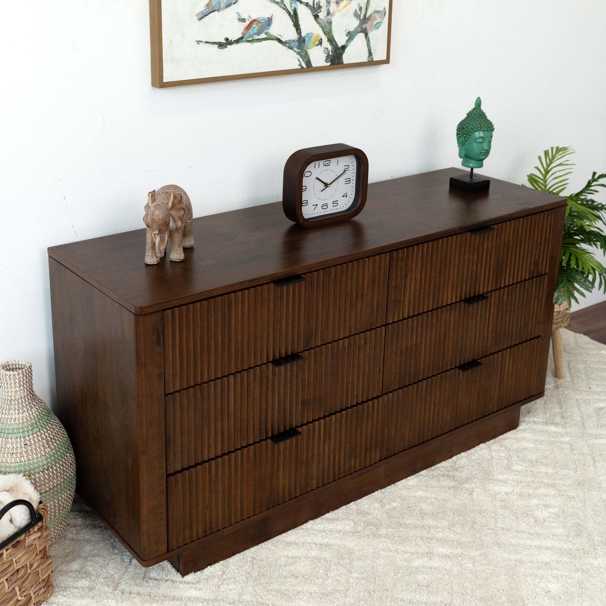 Modern dark wood dresser with decor, table clock, and elephant figurine in a cozy room