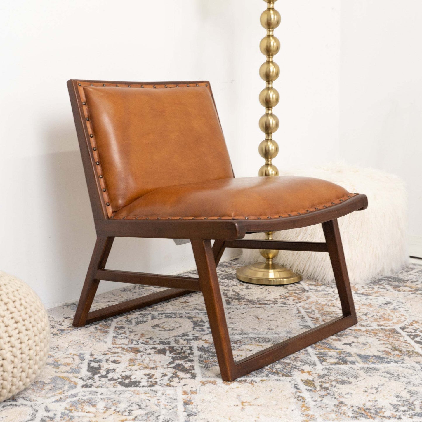 Modern brown leather accent chair with wood frame on patterned rug, FredCo furniture