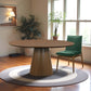 Modern dining room with round wooden table, green chair, and indoor plants on hardwood floors