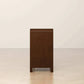 Dark wood nightstand side view in modern room, FredCo International furniture.