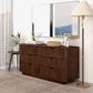 Modern bedroom setup featuring a dark wood dresser, decor accents, mirror, and floor lamp