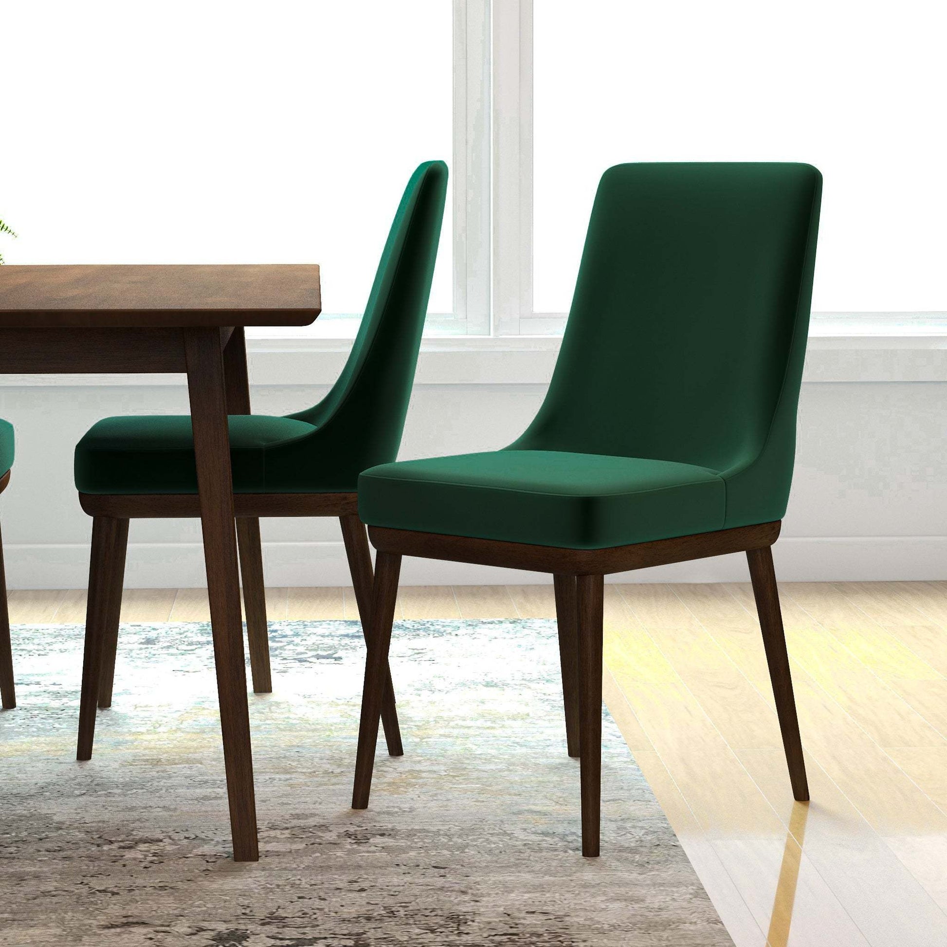Modern green dining chairs with wood legs next to a wooden table in a bright home setting