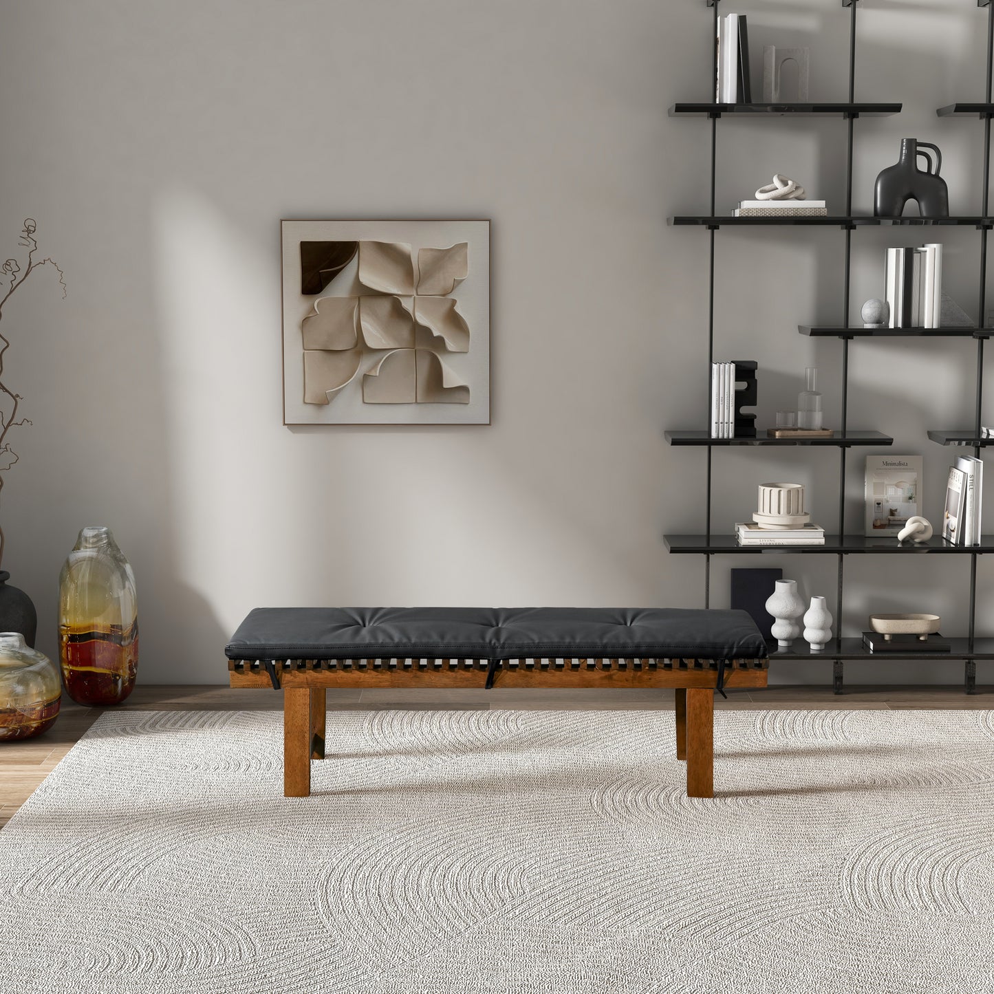 Modern living room with black bench, abstract wall art, open shelving, and textured rug