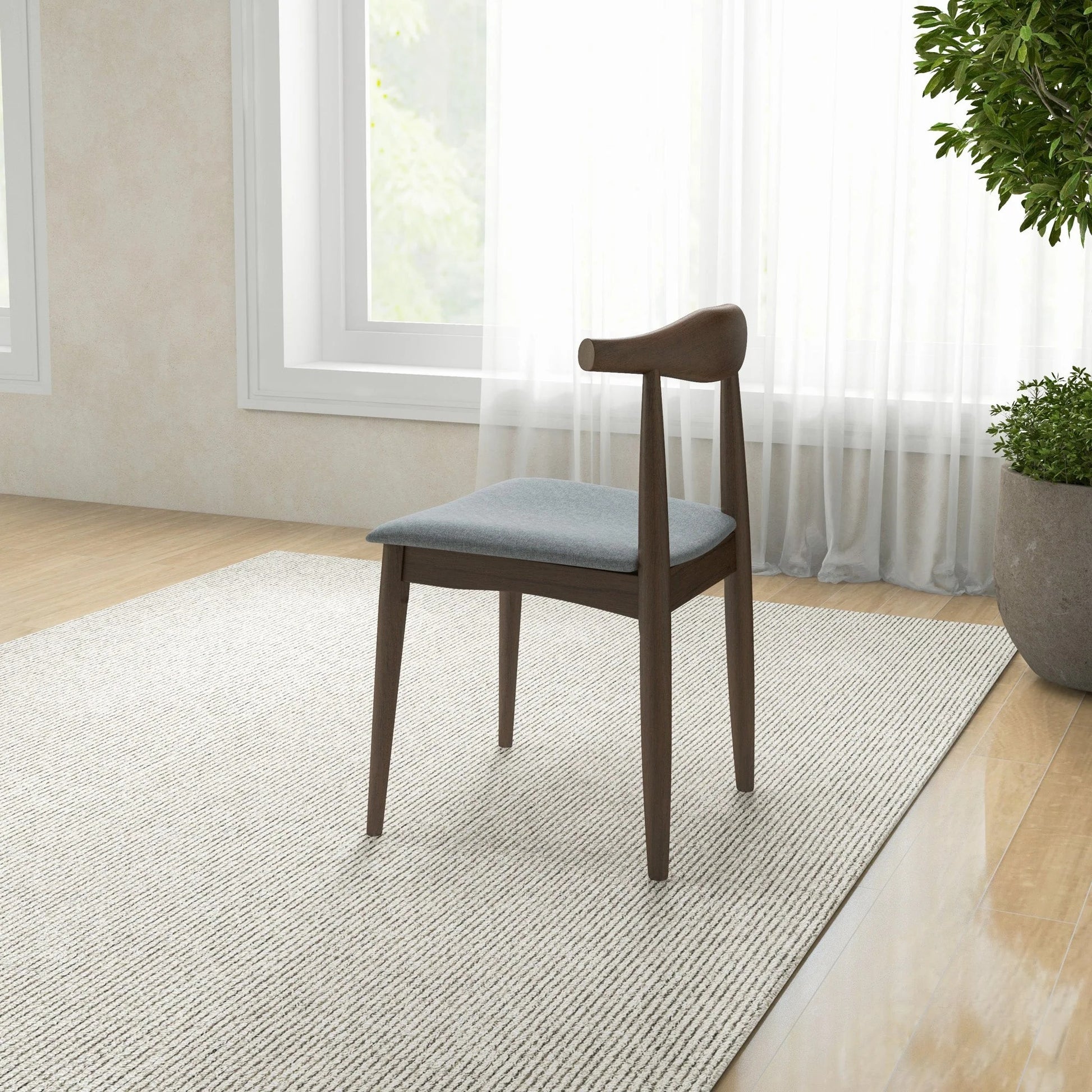 Modern wood dining chair with gray cushion on rug in bright living room, FredCo International furniture