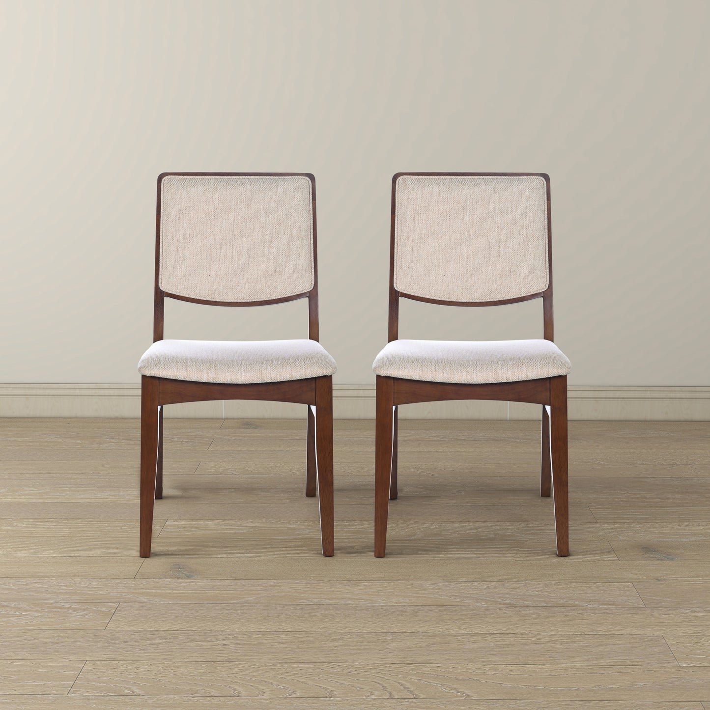 Pair of modern wood dining chairs with beige fabric seats on hardwood floor, FredCo International