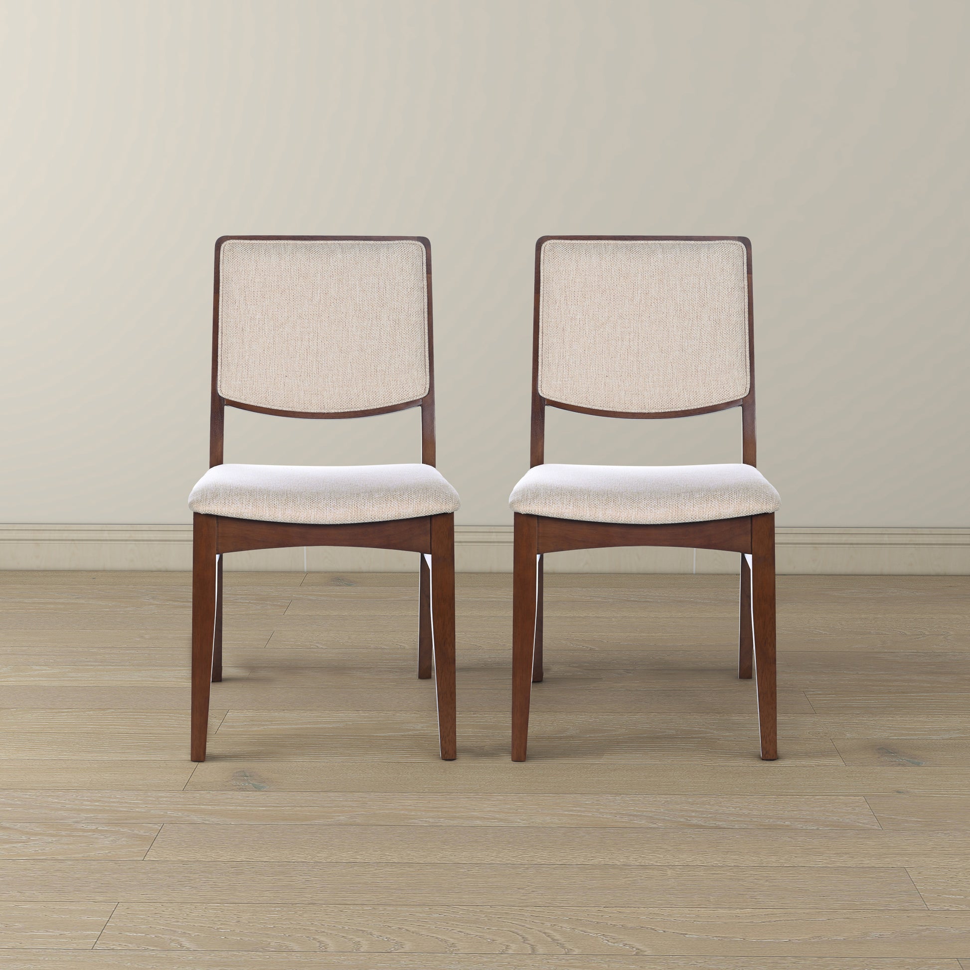 Pair of modern wood dining chairs with beige fabric seats on hardwood floor, FredCo International