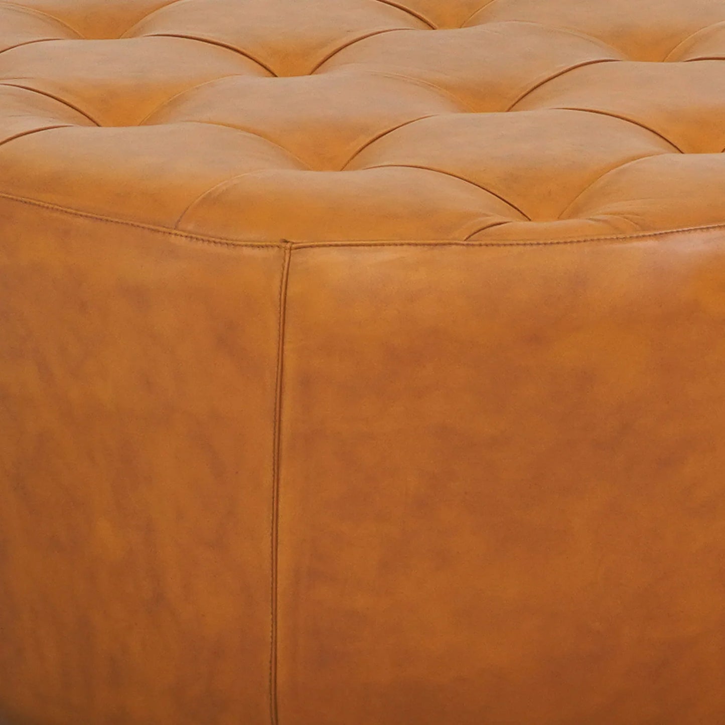 Tufted tan leather ottoman close-up, modern home furniture from FredCo International
