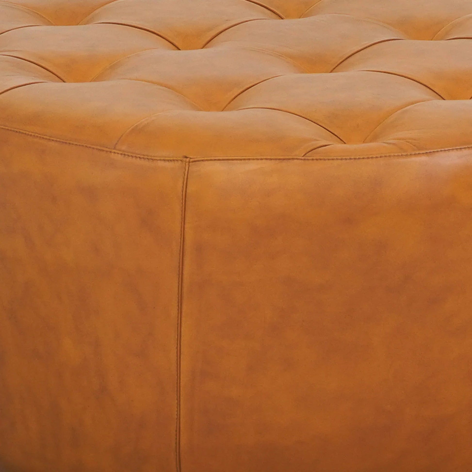 Tufted tan leather ottoman close-up, modern home furniture from FredCo International