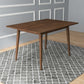 Modern wooden dining table on gray patterned rug in stylish home interior, FredCo International