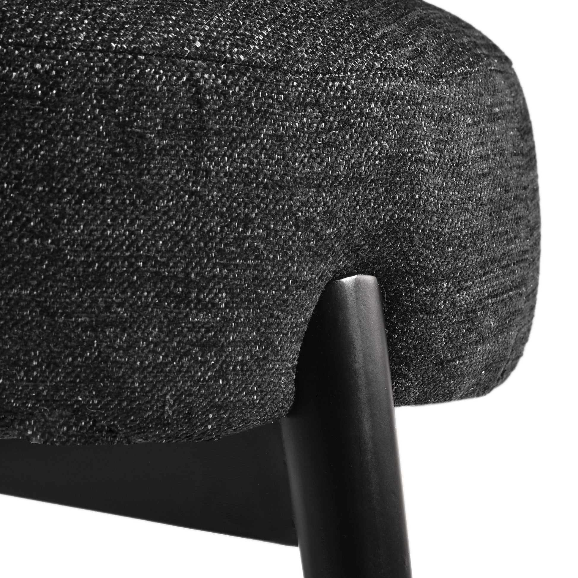 Close-up of modern black fabric chair seat with sturdy black leg, FredCo International furniture