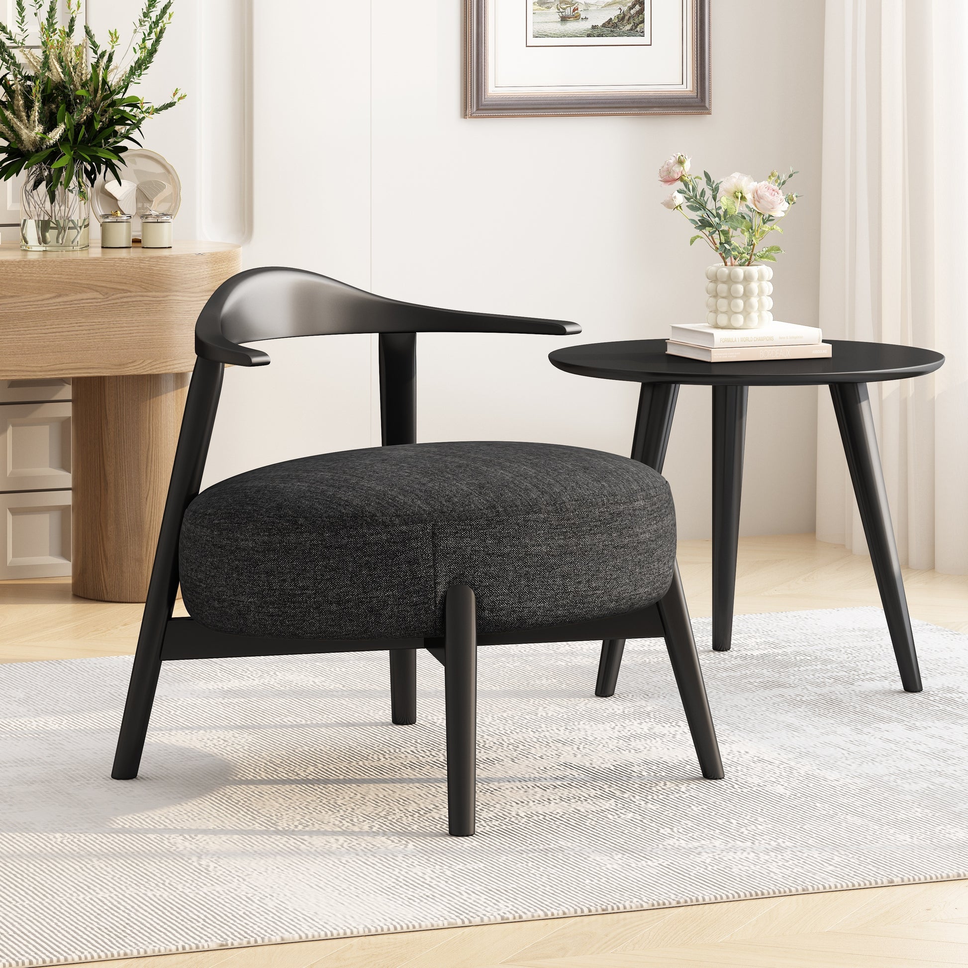Modern black accent chair with round seat and matching side table in stylish living room