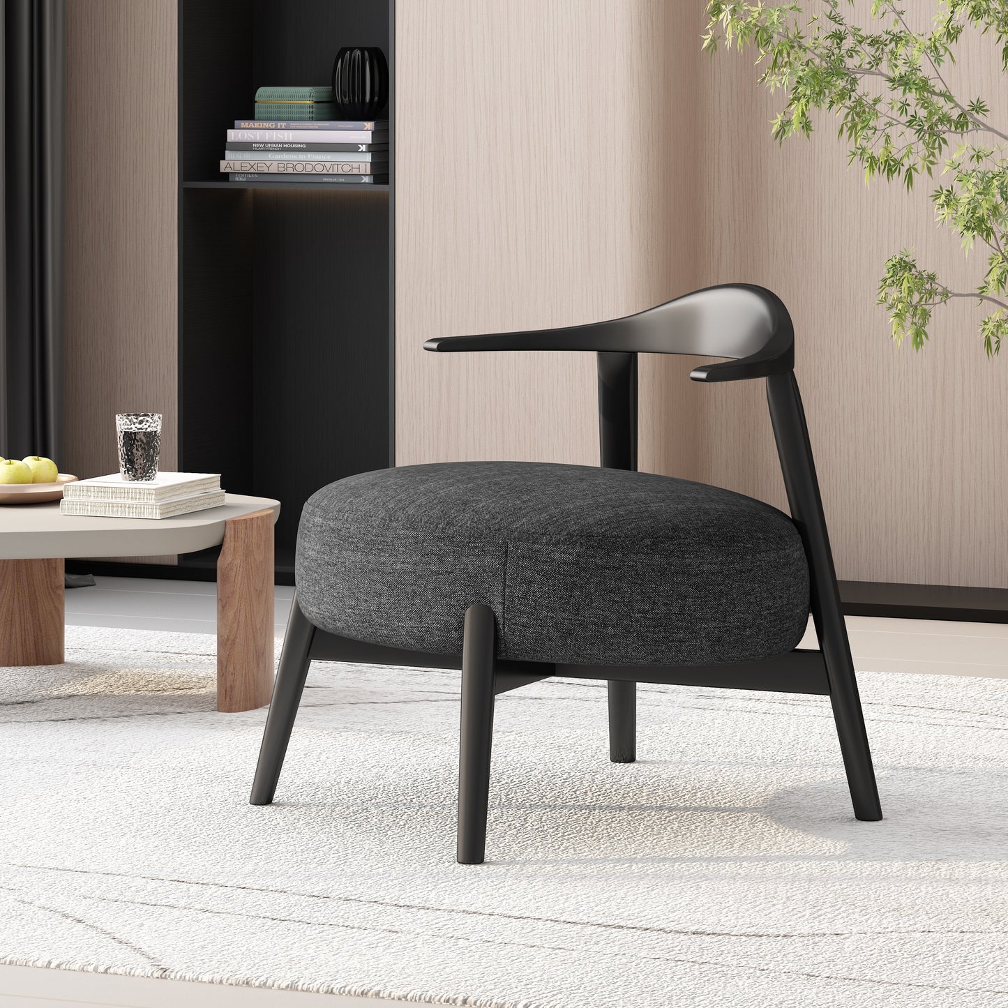 Modern black accent chair in a stylish living room with light wood paneling, books, and coffee table