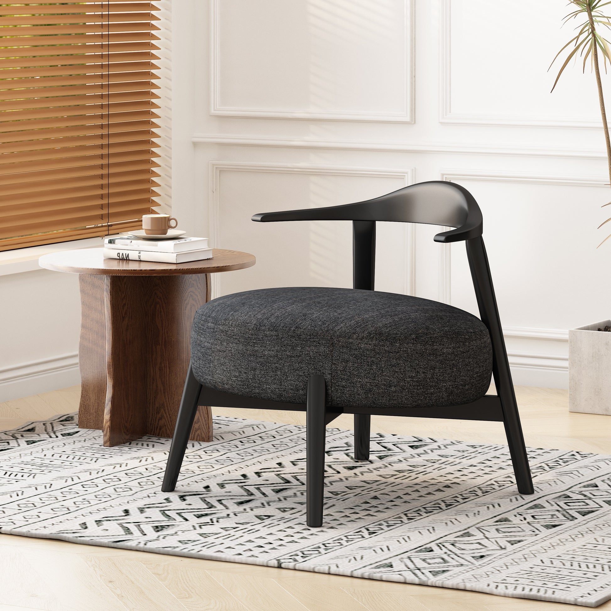 Modern black accent chair with round cushion beside wooden side table in bright living room