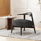 Modern black accent chair with round cushion beside wooden side table in bright living room